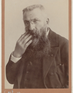 Portrait de Rodin avec des lorgnons, la main droite dans la barbe