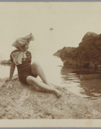 Femme non identifiée posant sur un rocher devant la mer