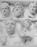 Onze têtes sculptées sur trois étagères